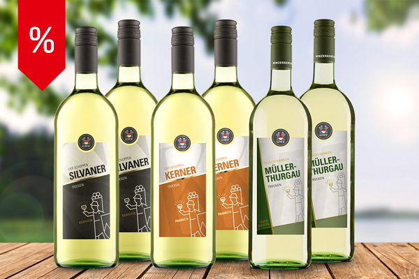 Sechs Literflaschen Weißwein aus dem Liter Mix-Paket vor sommerlicher Naturkulisse – 2 mal Silvaner, 2 mal Kerner, 2 mal Müller-Thurgau. Dahinter blauer Himmel, grüne Wiese, Bäume und ein See.